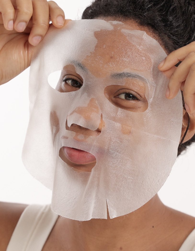 Black girl applying a vegan hydrating sheet mask